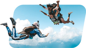 Outside camera skydiver filming a tandem skydiving pair in free fall