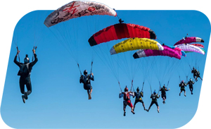Skydivers flying parachutes stacked