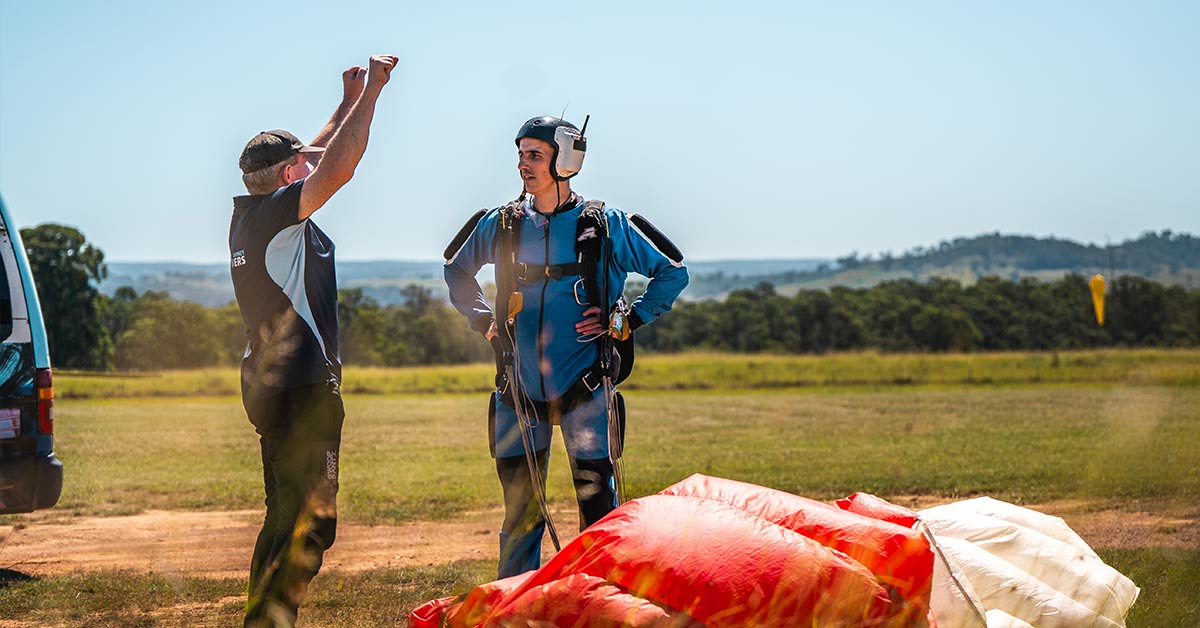 Skydiving instructor and student discussing parachute flight