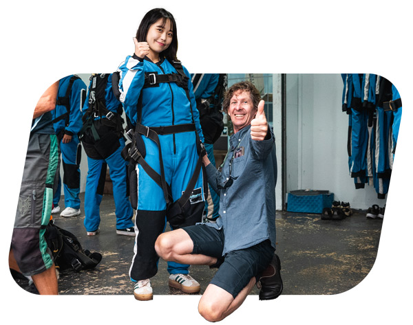 Skydiving instructor fitting harness on passenger