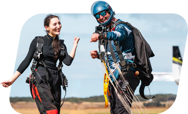 Tandem skydiving passenger in Australia posing for a video filmed by her skydiving instructor