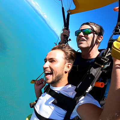 Passenger and skydiving instructor flying a parachute over Airlie Beach