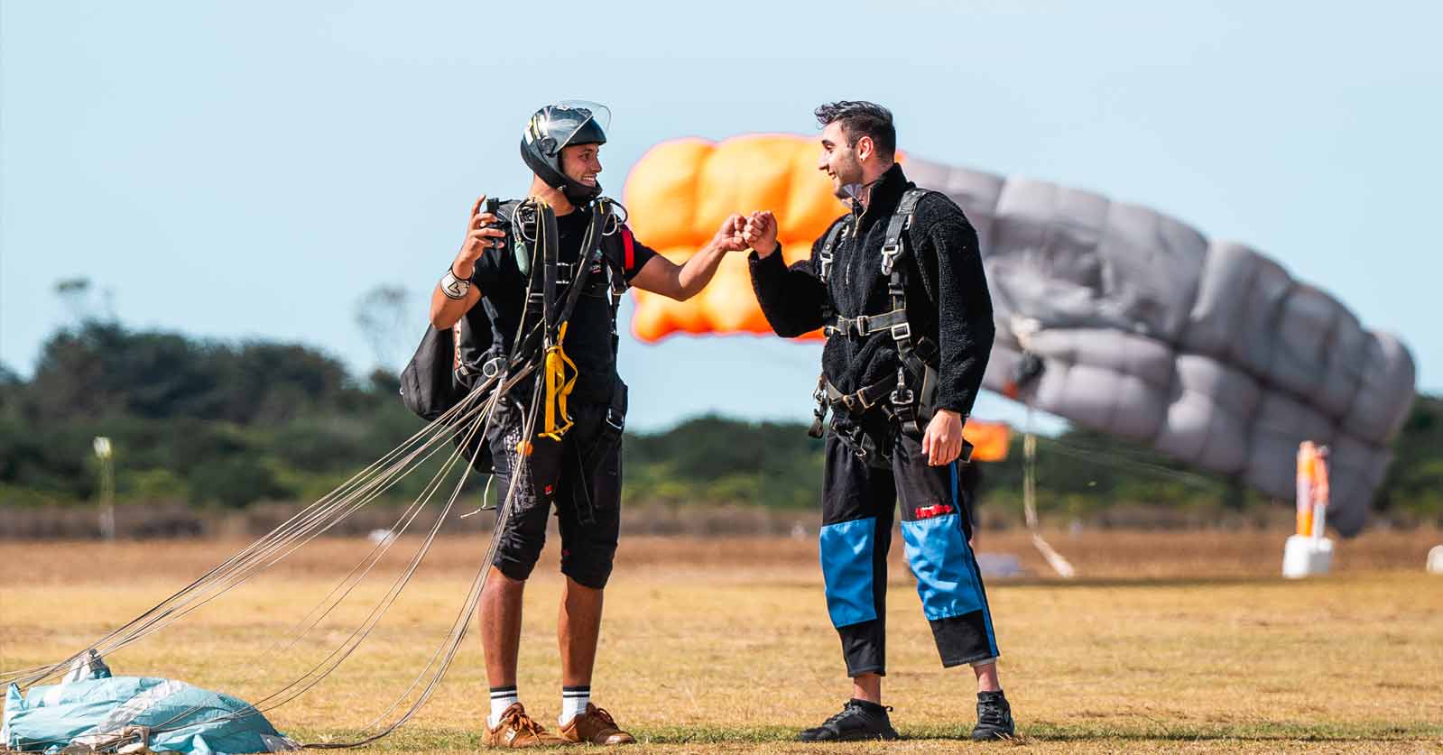 Skydiving instructor and customer fist bumping