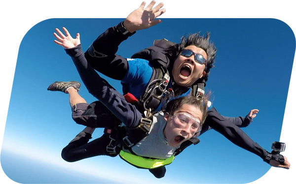 tandem skydiving instructor filming passenger with wrist-mounted camera