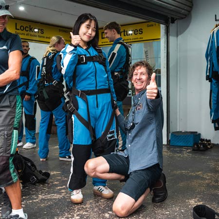 SKYONE skydiving staff member putting harness on customer