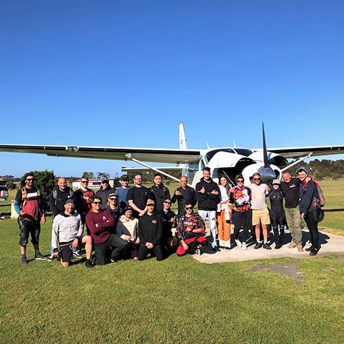 Group of skydivers in front of plane
