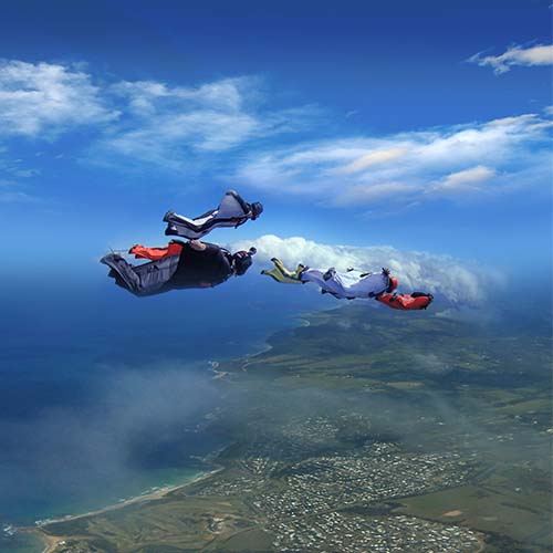 Licensed skydivers wingsuit flying over Torquay