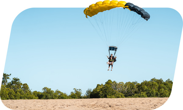 Instructor and customer skydiving in Airlie Beach and landing on the Beach in the Whitsundays region