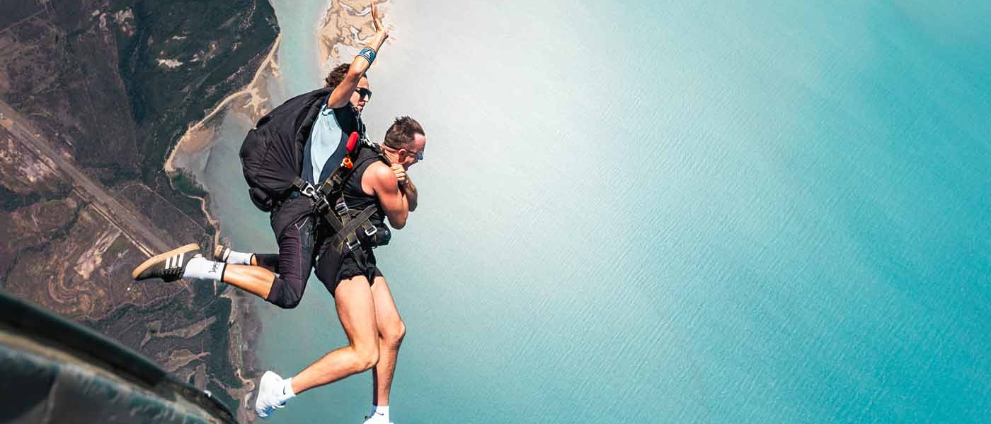 Skydiving instructor and customer exiting plane over Airlie Beach