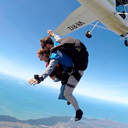 tandem skydiving pair exiting plane over Cairns