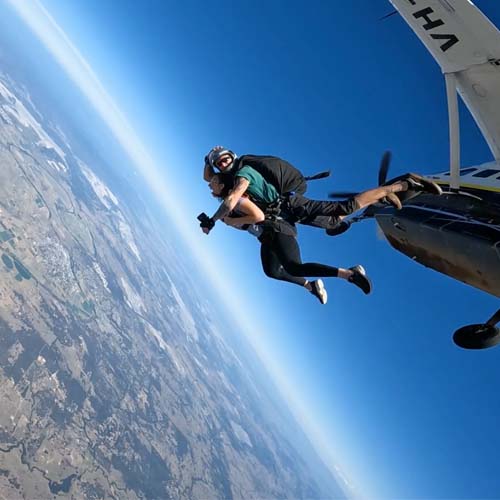 Tandem skydiving pair exiting plane over the Hunter Valley