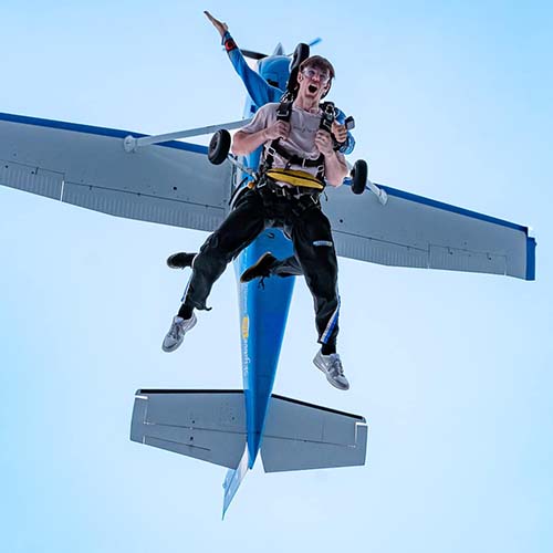 customer exiting plane with skydiving instructor over Moruya