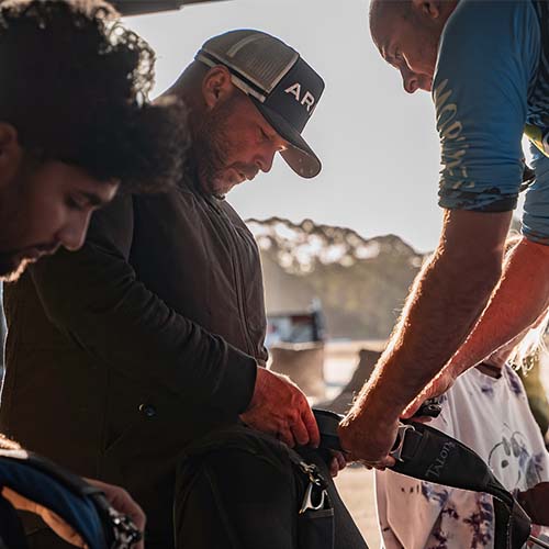 Skydiving instructor adjusting student's harness