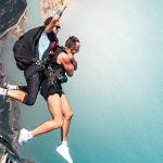 Skydiving instructor and customer exiting plane