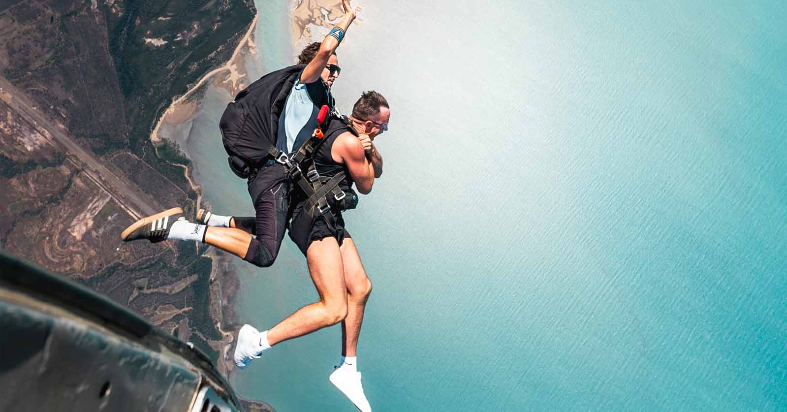 Skydiving instructor and customer exiting plane