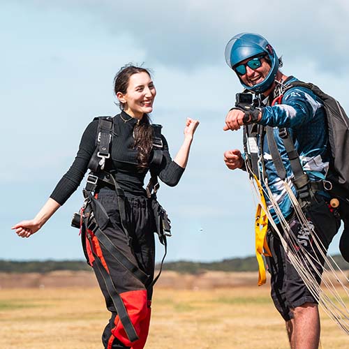 Skydiving instructor gives thumbs up to nervous-looking first-time jumper before takeoff