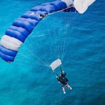 skydiving parachute flying over the ocean