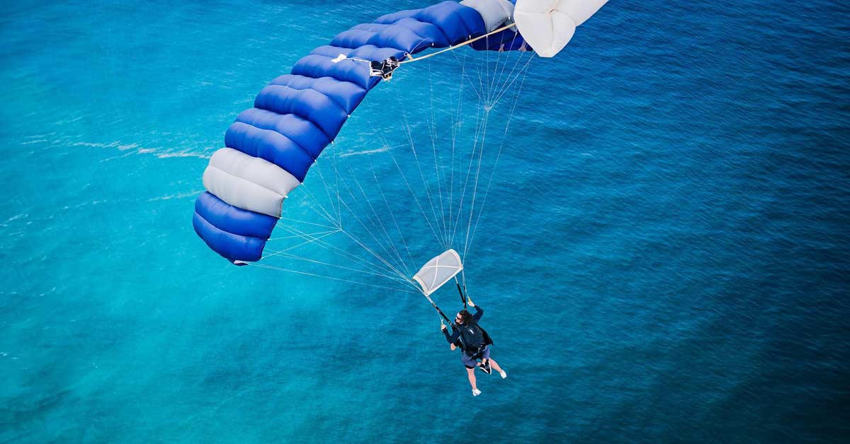 skydiving parachute flying over the ocean