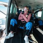 customer and skydiving instructor about to exit plane